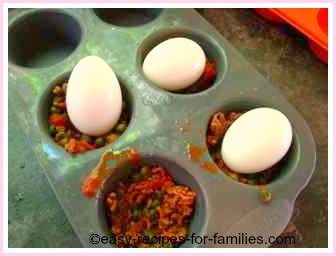 place eggs in the center of the mold lined with some meat sauce