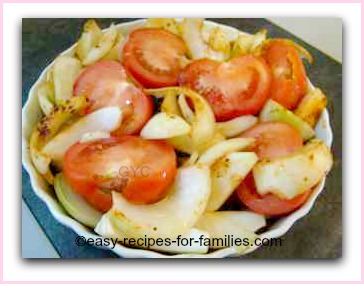 Sliced tomatoes and onions in the flan tray