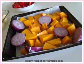 roasting tray with onions and pumpkin ready for roasting