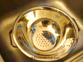 Colander in the sink ready to drain the cooked spaghetti.
