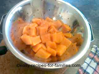 Stewed pumpkin draining in a colander, in the process of making pumpkin puree 