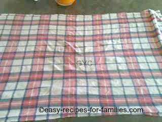 Clean wet tea towel laid out on the counter top for the next step in making the pumpkin cake roll