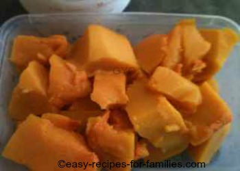 Stewed pumpkin pieces measured in a measuring cup