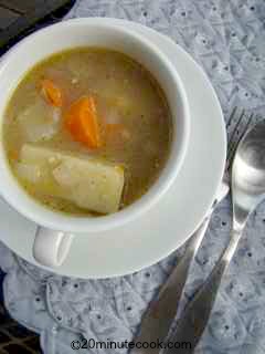 Serving of chicken soup in a large tea cup and saucer