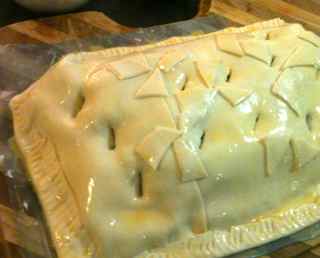 Place the top of pastry over the ground beef wellington, decorate and apply egg wash