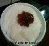 A bowl of milky oozy creamy rice pudding with a dollop of jam
