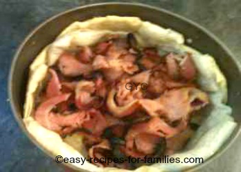 Cooked bacon in the base of the pastry shell