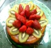 A pumpkin pie cake decorated with strawberries and kiwi Fruit